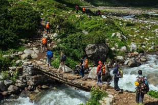 Hampta Pass TTH Trekkers crossing bridge on river
